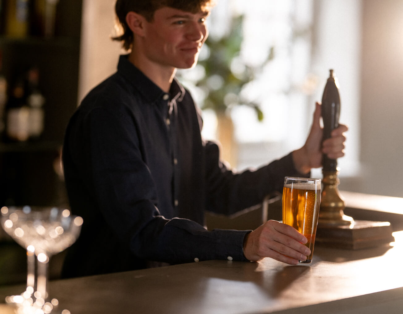 Barman serving a pint of beer at Barnsgrove, Hampshire