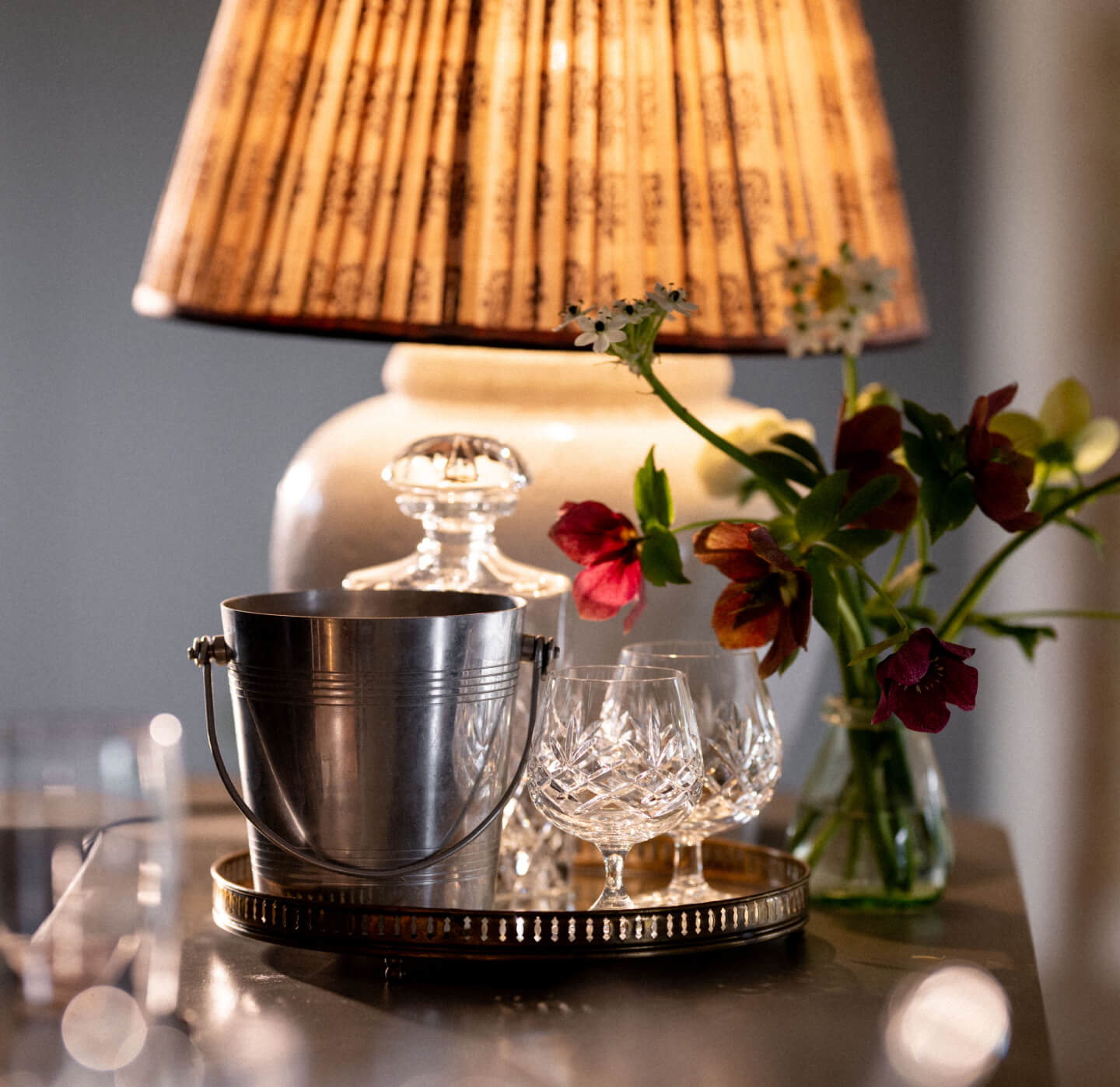 Lamp and drinks table with crystal glasses at Barnsgrove, Hampshire