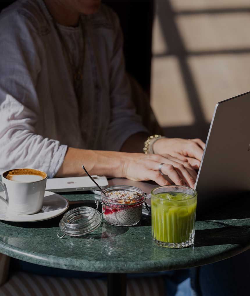 Barnsgrove Workspaces. Someone working on a laptop over breakfast.